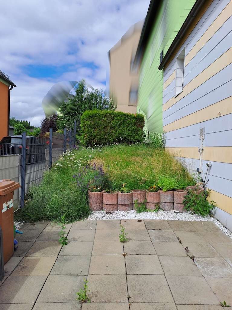 Terrasse mit kleinem Garten hinter dem Haus
